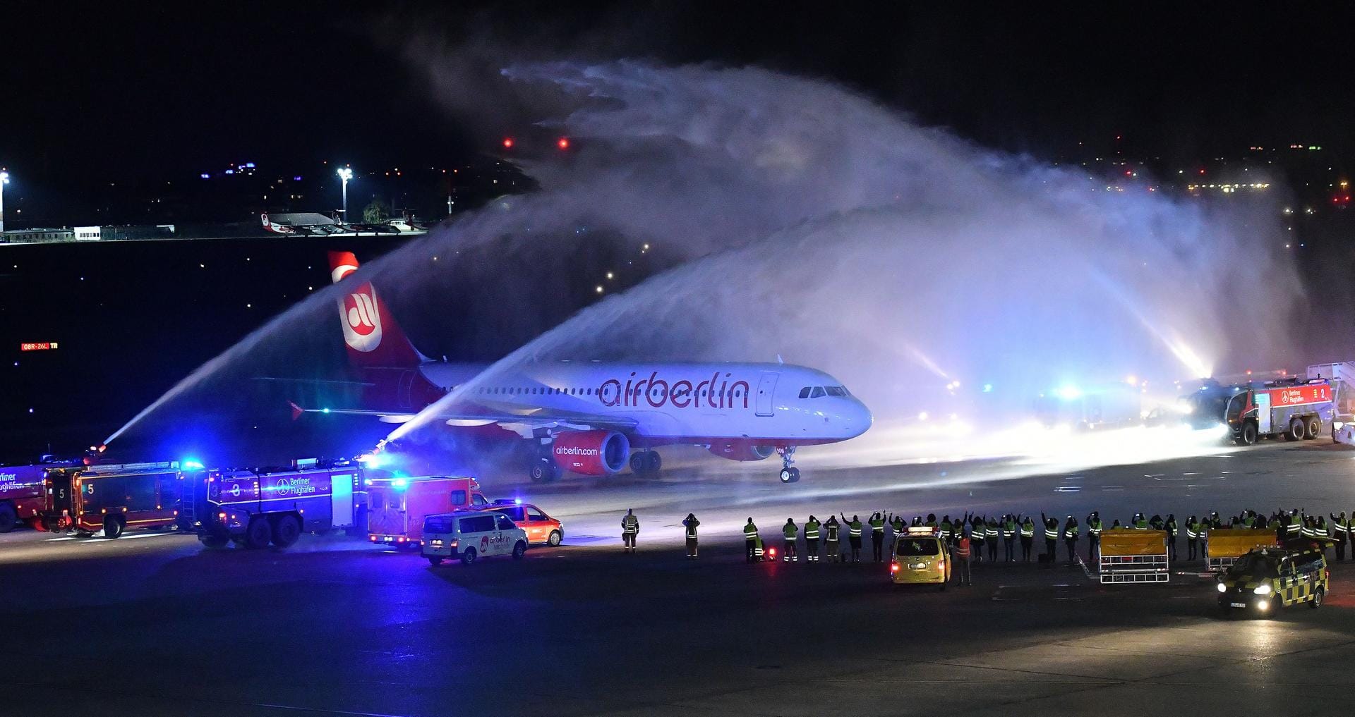 Die letzte Maschine der Fluggesellschaft Air Berlin ist am 27. Oktober in Berlin nach ihrem Flug von München gelandet und wird von der Feuerwehr auf dem Rollfeld mit Wasserfontänen empfangen.