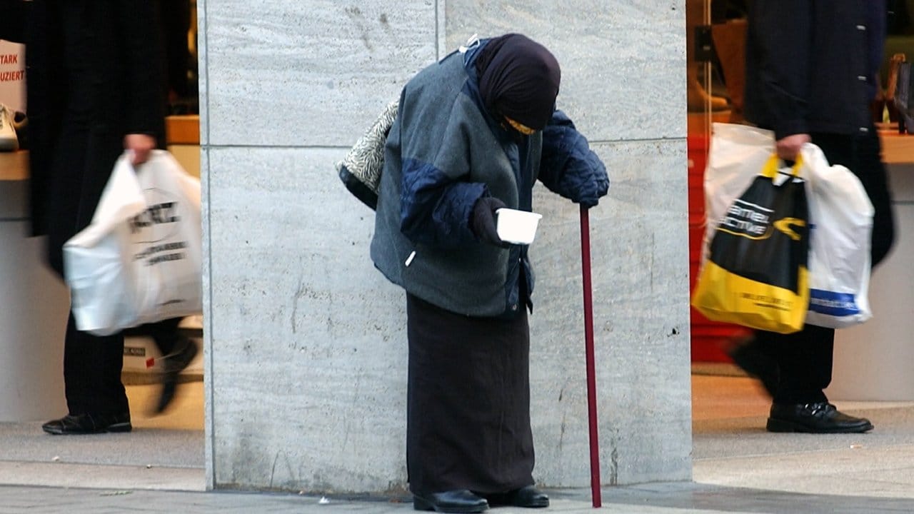 In der Kölner Innenstadt bittet eine alte Frau um Almosen. In der Kölner Innenstadt bittet eine alte Frau um Almosen.