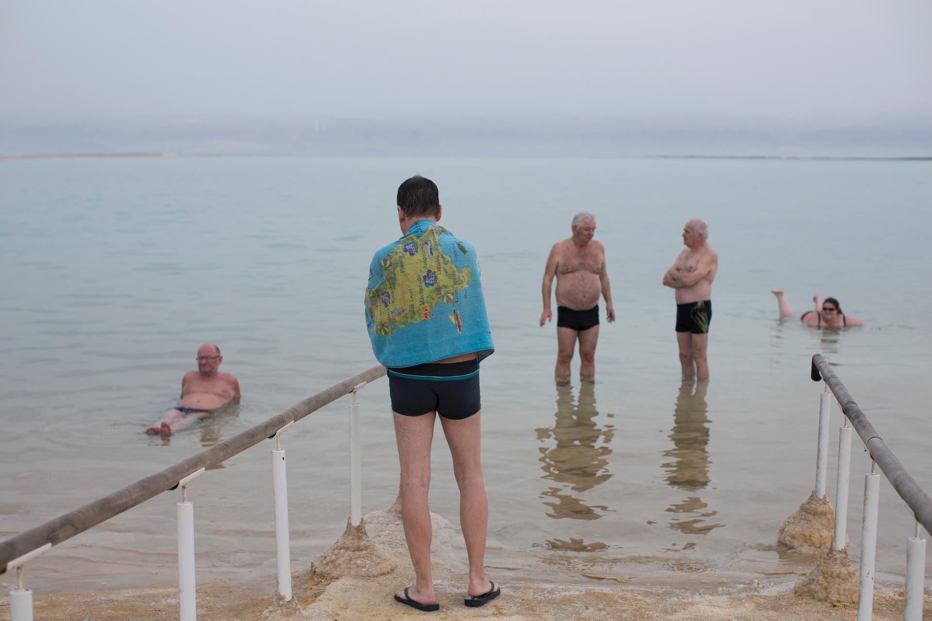Leute baden im Toten Meer am "Ein Bokek Resort".