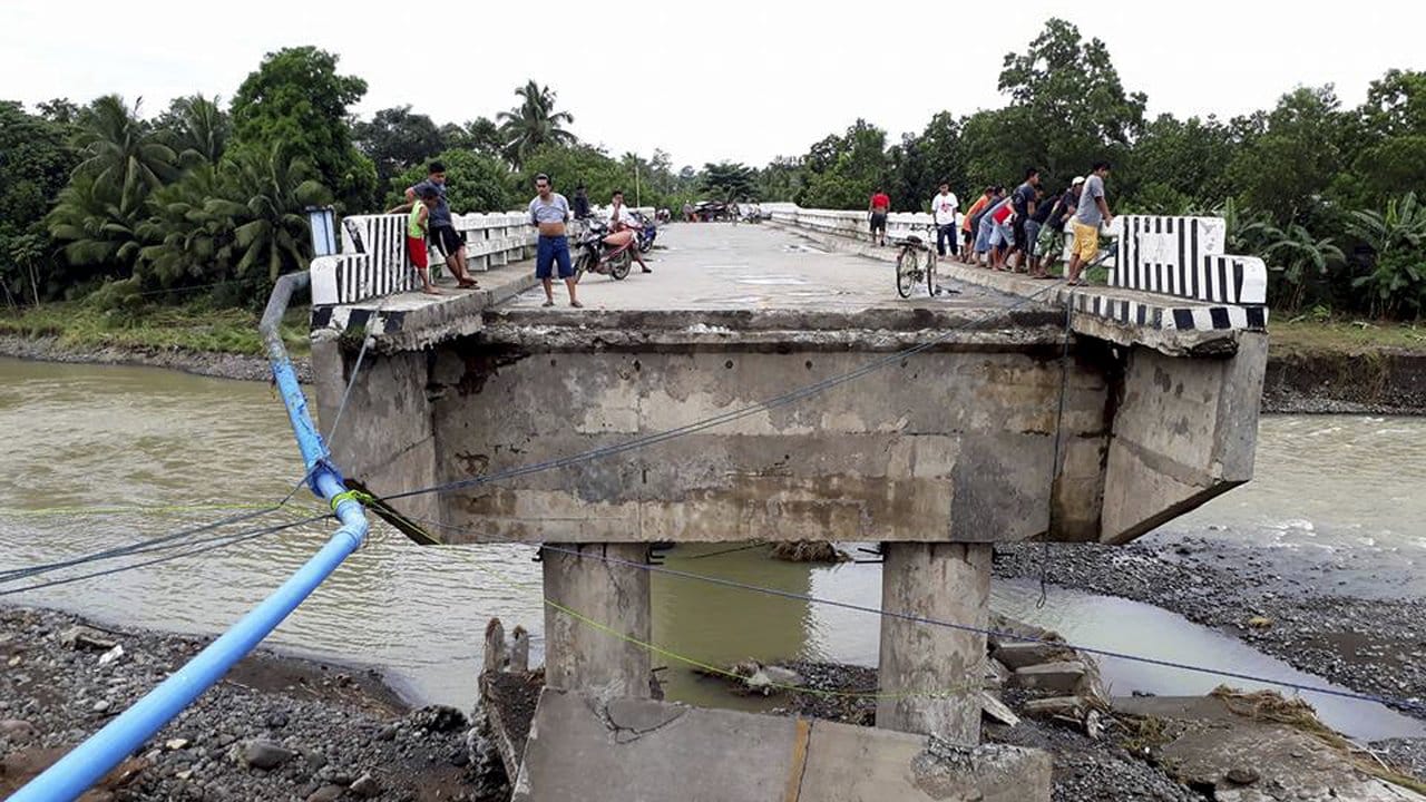Auf den Philippinen: Einheimische blicken an Heiligabend bei Zamboanga Del Sur von einer während des Sturms beschgädigten Brücke. Auf den Philippinen: Einheimische blicken an Heiligabend bei Zamboanga Del Sur von einer während des Sturms beschgädigten Brücke.