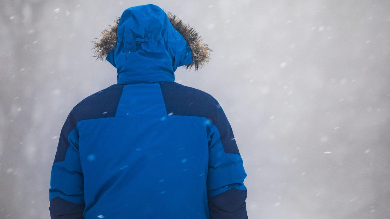 Ein Mann steht auf dem Großen Feldberg (Hessen) bei Nebel und Schneetreiben an einem Schlittenhang: Zum Jahresende könnte es auch noch einmal Neuschnee geben.