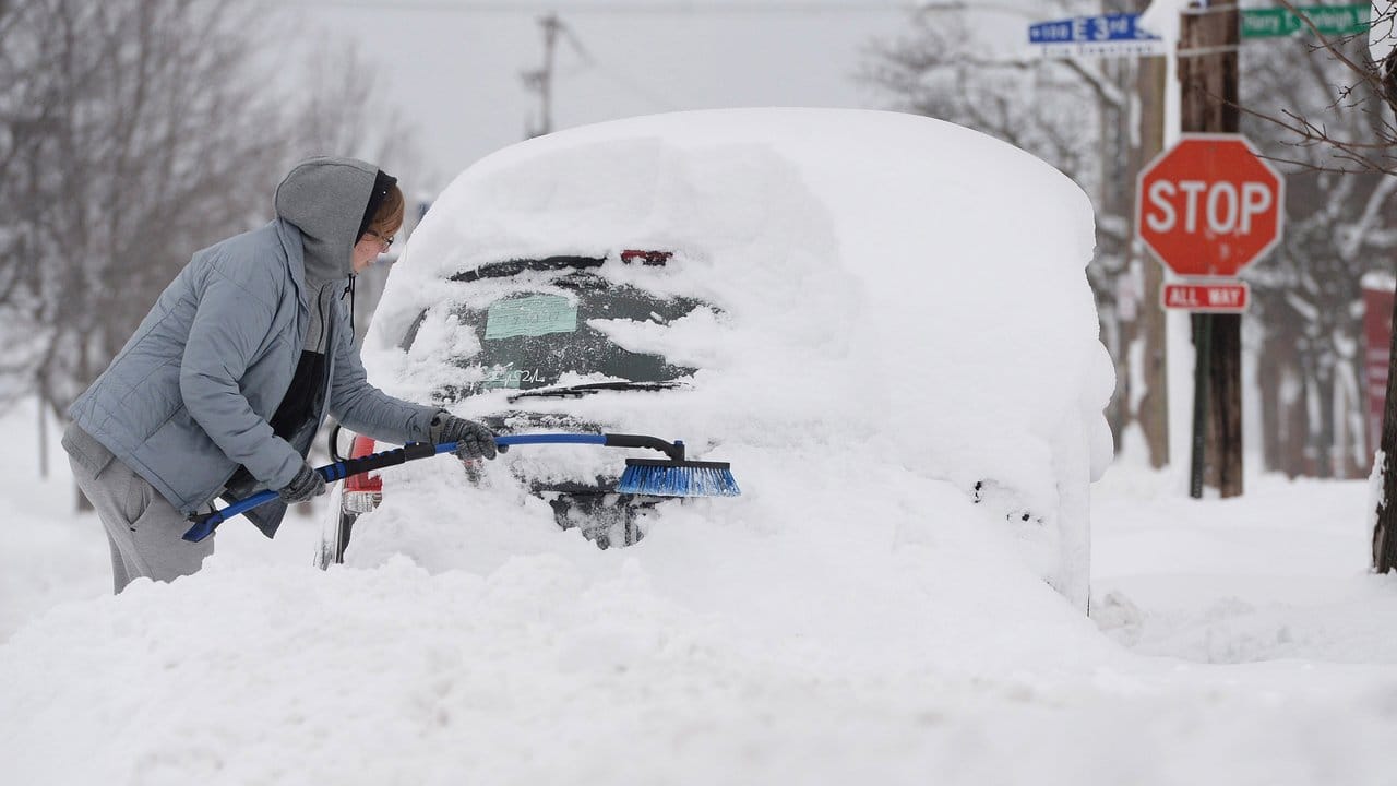 Ein Amerikaner versucht im US-Bundesstaat Pennsylvania sein Auto vom Schnee zu befreien.