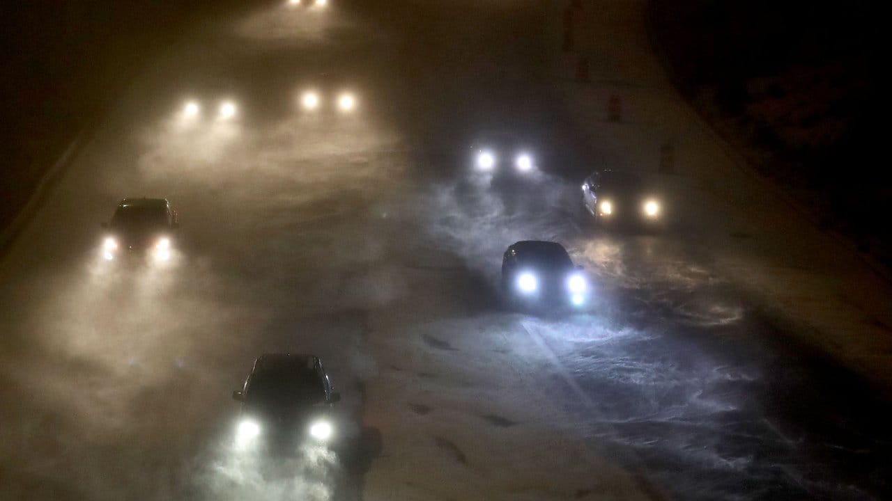 Autofahrer tasten sich in Minneapolis vorsichtig über eine verschneite Straße.