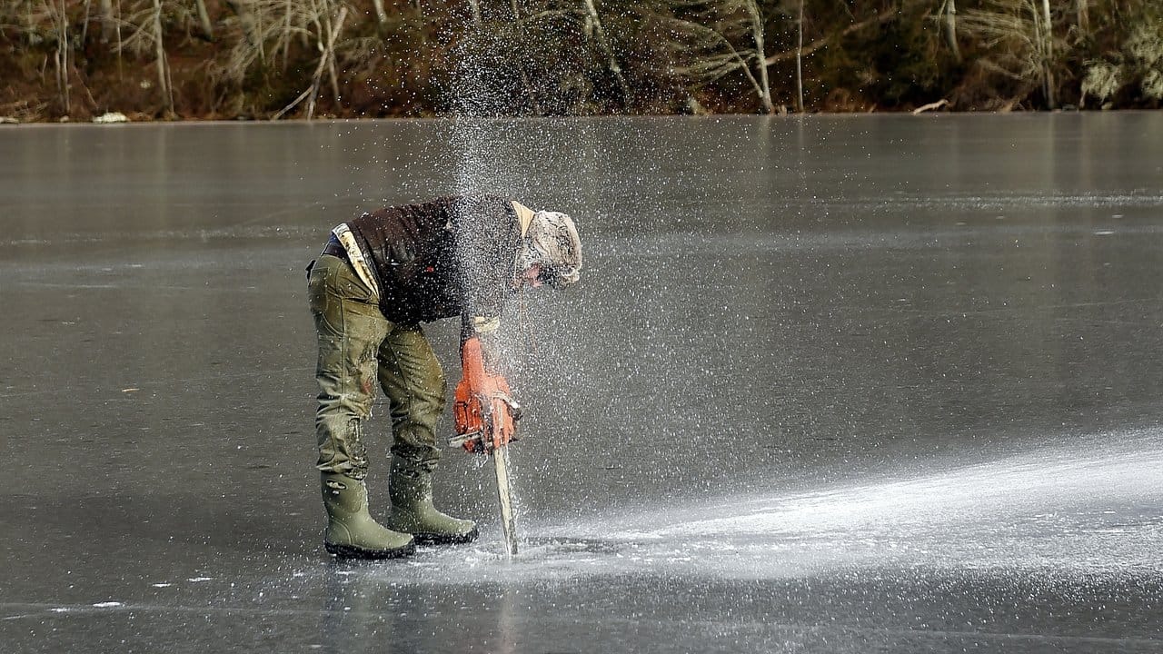Für die Eisfischer ist es ein Vergnügen: Pete Wall benutzt in Ledyard (Connecticut) eine Kettensäge, um Löcher in den zugefrorenen Lantern Hill Pond zu sägen.