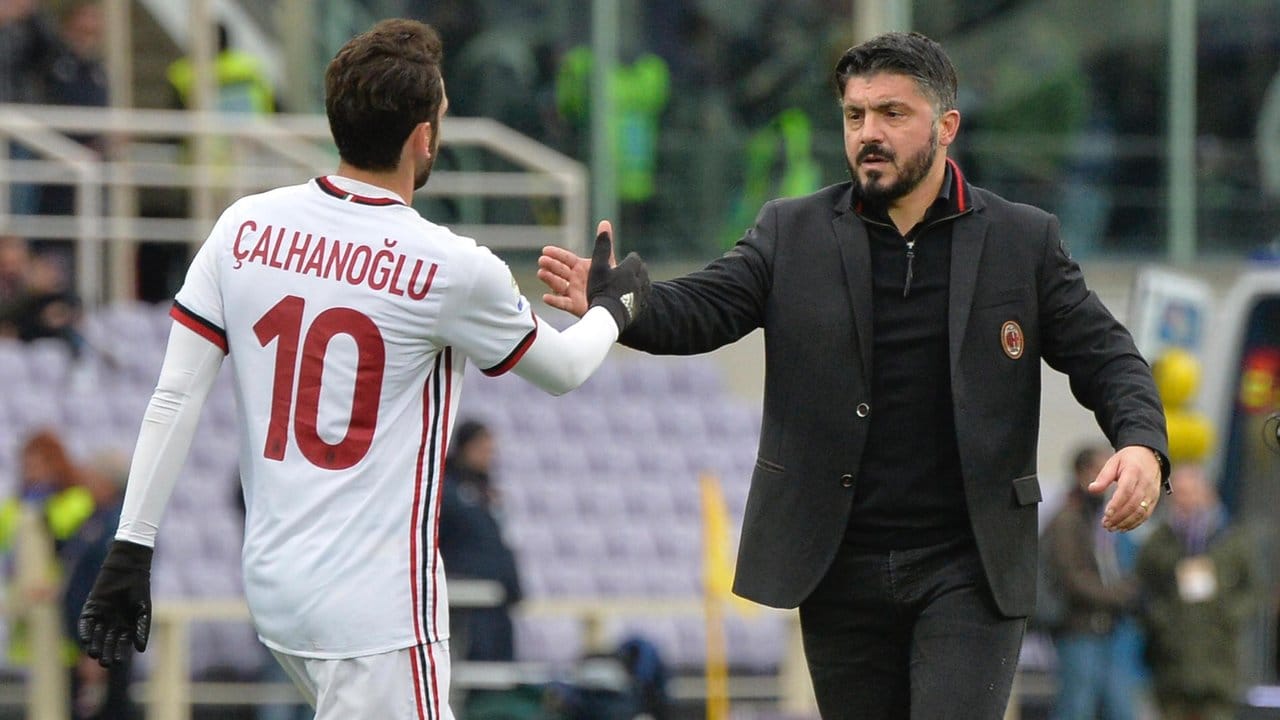Hakan Calhanoglu (l) und der Trainer des AC Mailand, Gennaro Gattuso, geben sich nach dem 1:1 die Hand.