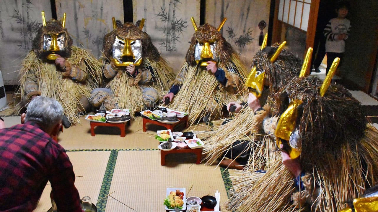 Ein Mann serviert in Akita (Japan) den "Namahage-Dämonen" ein Festmahl.