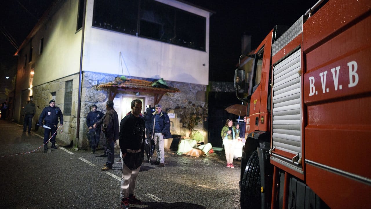Polizisten und Einwohner am Ort der Feuerkatastrophe.