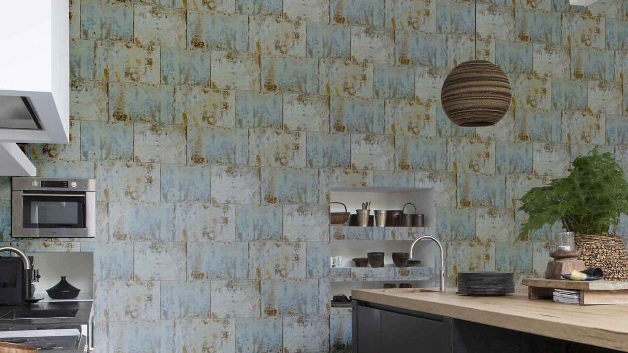 Mit Patina: Rasch gestaltet eine Küchenwand mit einer Tapete im Industrie-Look in zarten Blautönen.