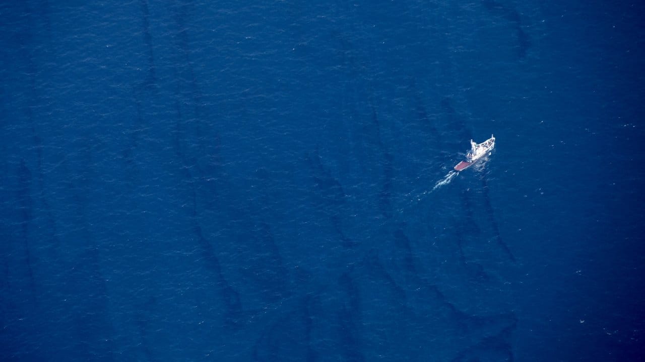 Ein Boot durchkreuzt im Ostchinesischen Meer einen Ölteppich, der von dem versunkenen iranischen Öltanker "Sanchi" verursacht wurde.