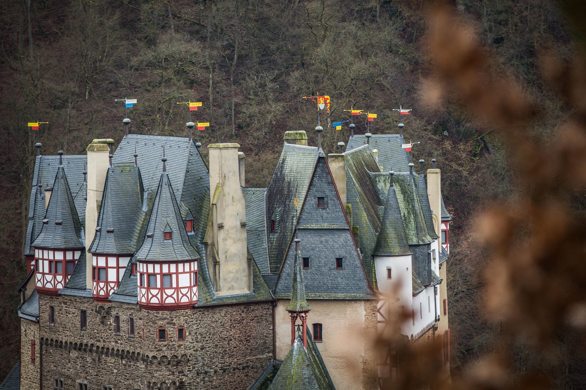 Burg Eltz: Mit bunten Blechwimpeln sind in der Nähe von Wierschem (Rheinland-Pfalz) die zahlreichen Spitzen und Dächer von Burg Eltz verziert.