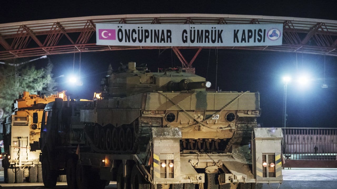 Mit Panzern und anderen gepanzerten Fahrzeugen beladene Lastwagen des türkischen Militärs passieren die türkisch-syrische Grenze.
