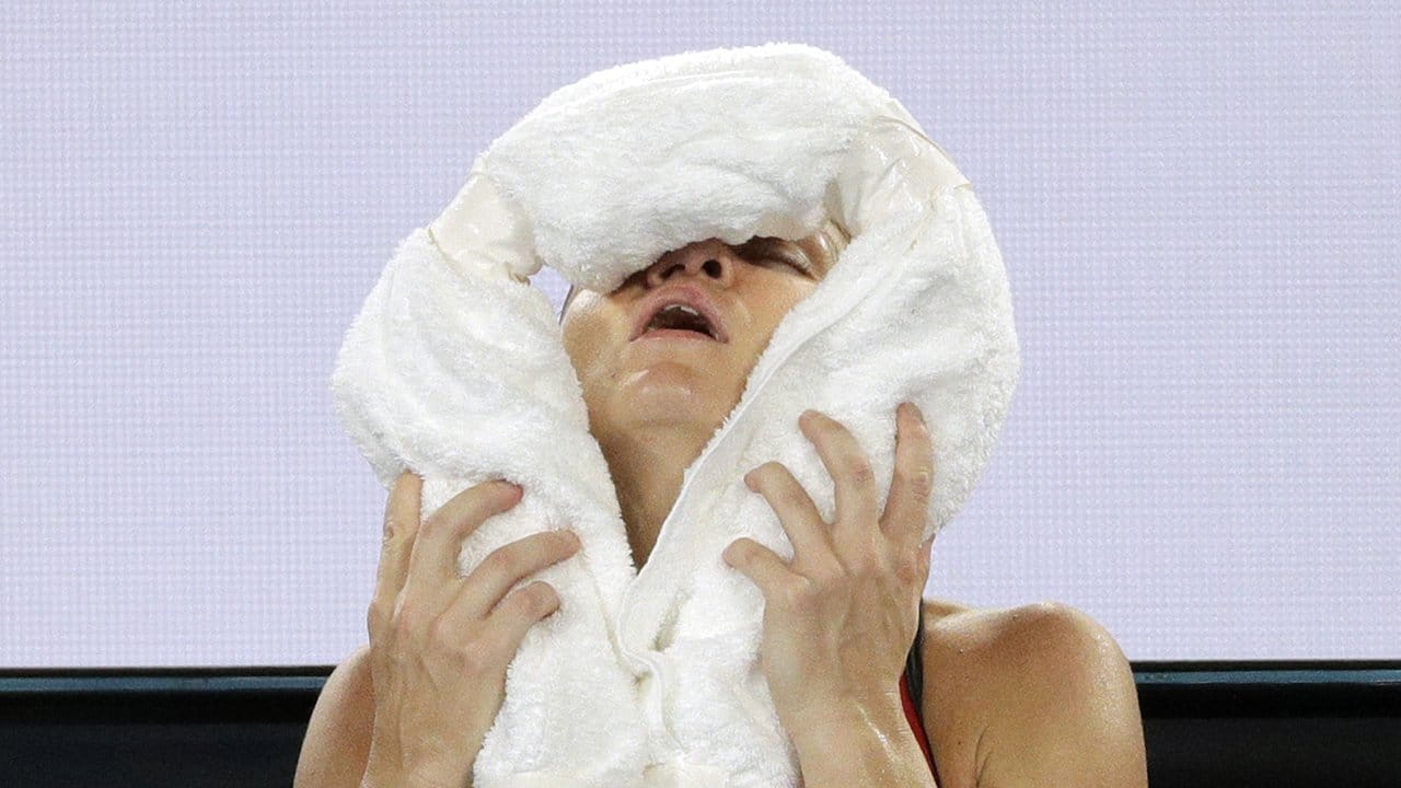 Simona Halep hält sich enttäuscht ein kaltes Handtuch ins Gesicht.
