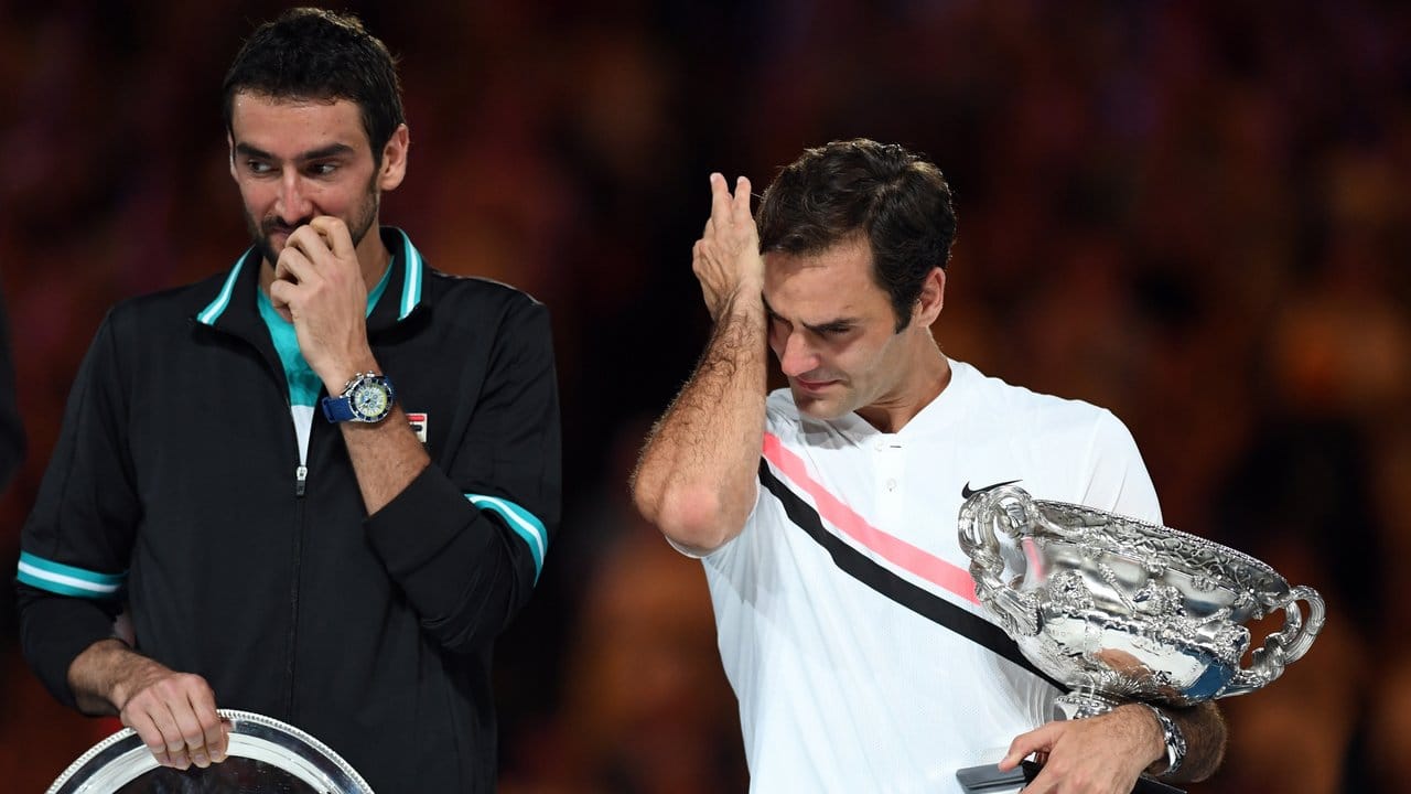 Roger Federer (r) wischt sich bei der Siegerehrung die Tränen aus dem Gesicht.