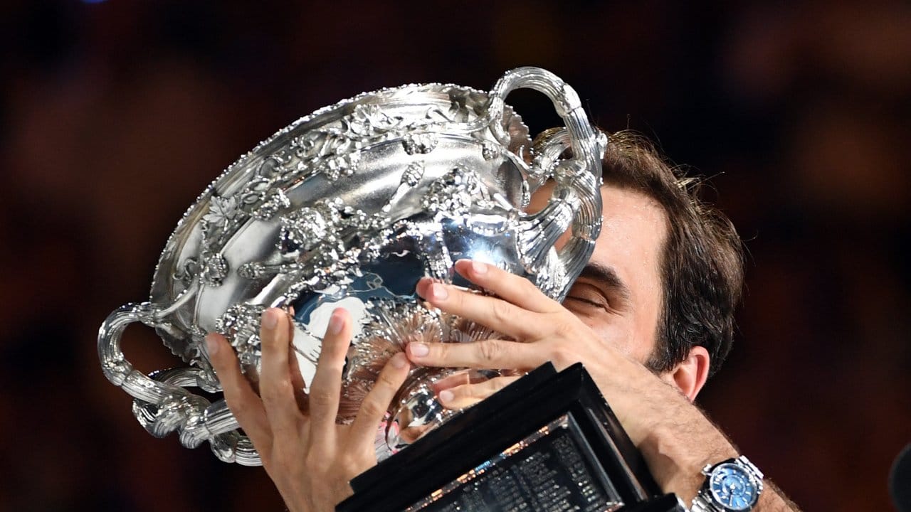 Roger Federer küsst nach seinem Sieg den Pokal - sechs Mal.