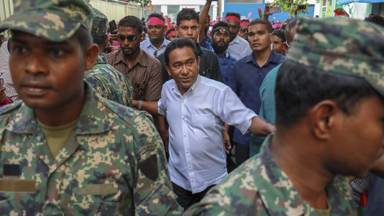 Der Präsident der Malediven, Abdulla Yameen Abdul Gayoom, geht mit seinen Sicherheitsbeamten zu einer Veranstaltung in Malé, um zu seinen Anhängern zu sprechen.