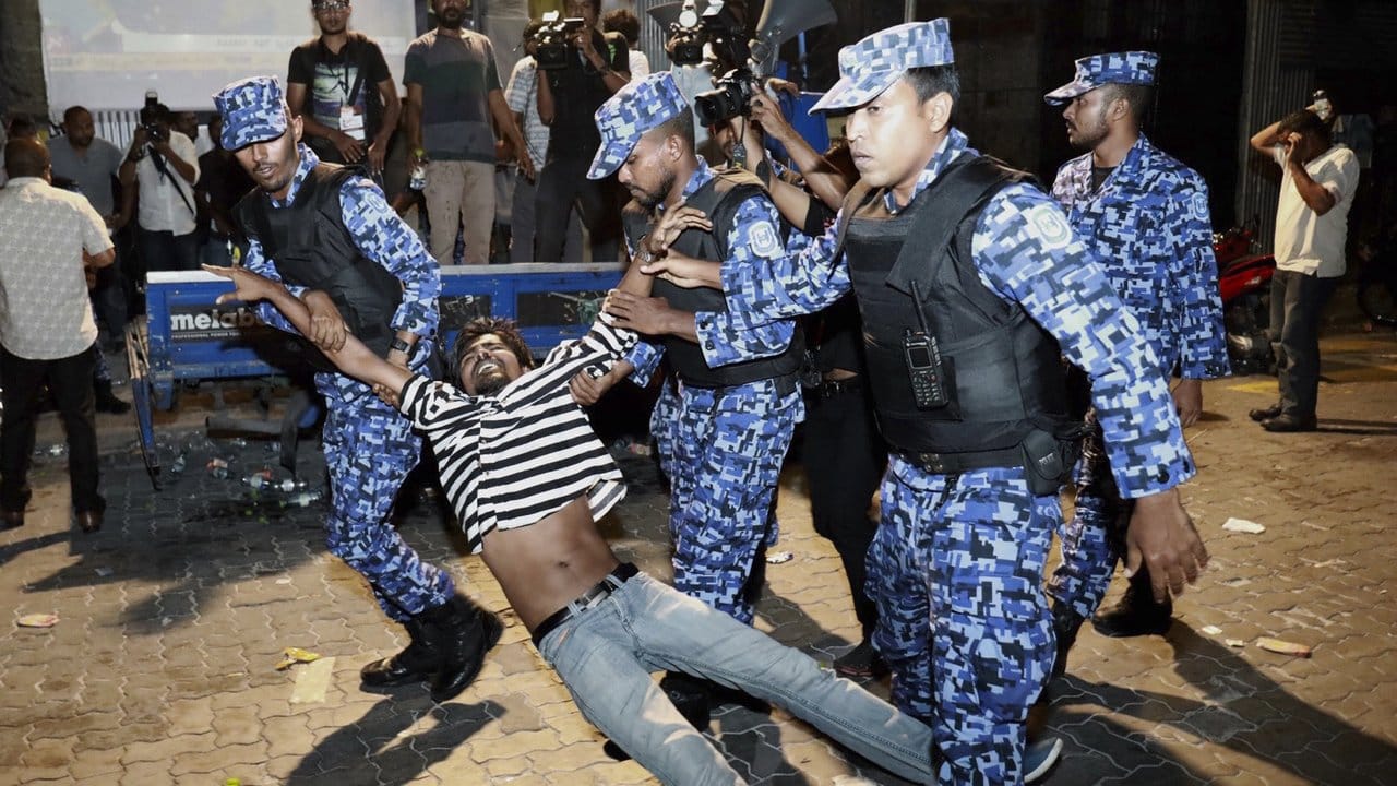 Polizisten nehmen einen oppositionellen Demonstranten fest, der die Freilassung von politischen Gefangenen fordert.