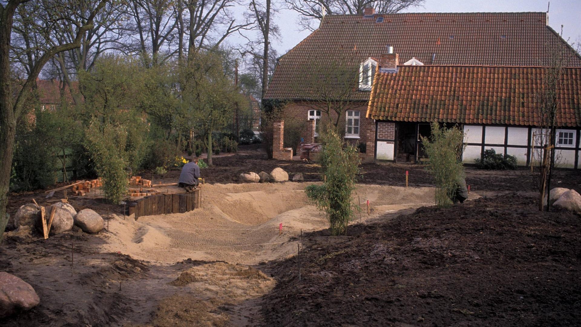 Anlegen eines Folien-Gartenteiches. Zuerst wird die Teichgrube ausgehoben und die Teichlandschaft mit Sand gestaltet.