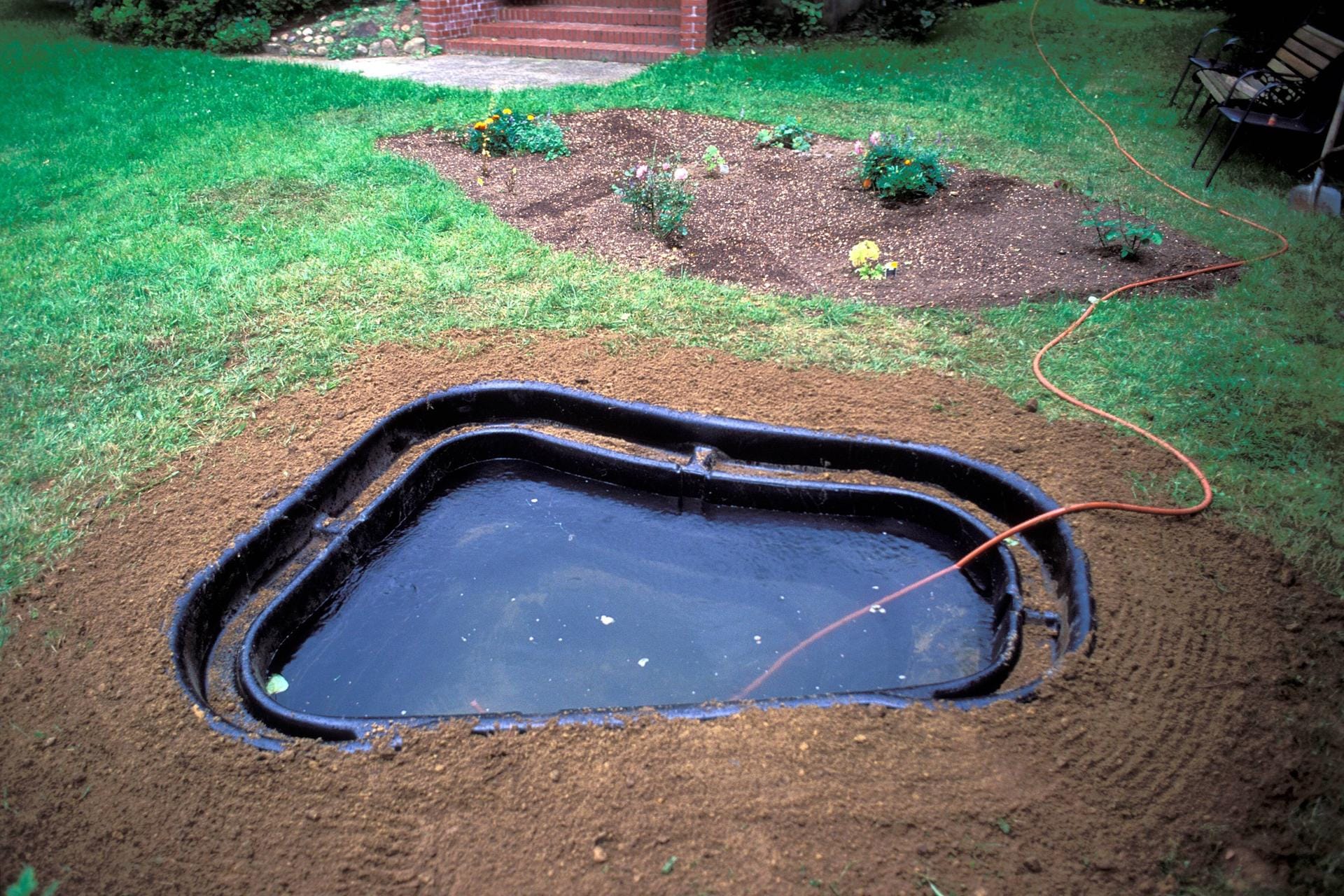 Anlegen eines Fertig-Gartenteiches: Schließlich wird das Wasser ins Teichbecken eingefüllt und der Gartenteich kann bepflanzt werden.