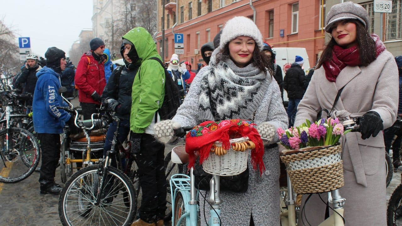 Irina (r) und ihre Freundin Natalja warten bei eisigen Temperaturen auf den Beginn der Fahrrad-Parade.