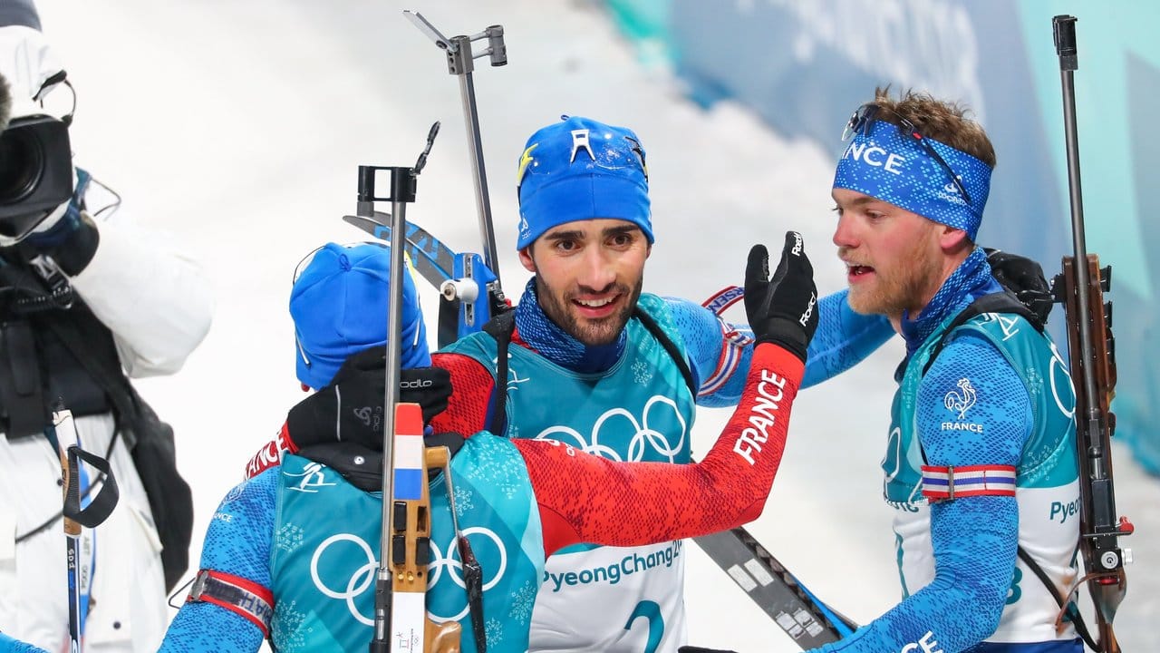 Olympiasieger Martin Fourcade wird von seinen französischen Teamkollegen beglückwünscht. Olympiasieger Martin Fourcade wird von seinen französischen Teamkollegen beglückwünscht.