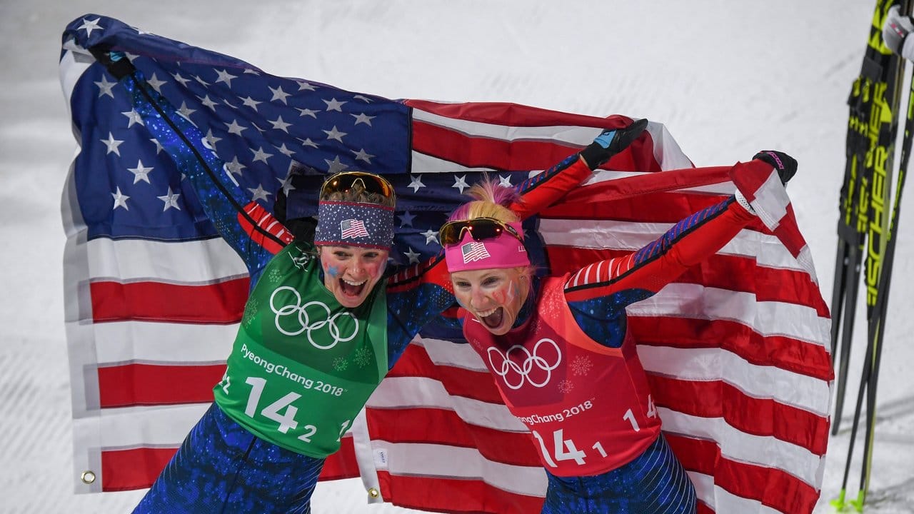 Kikkan Randall (r) und Jessica Diggins (l) aus den USA jubelen im Ziel über ihren Olympiasieg.