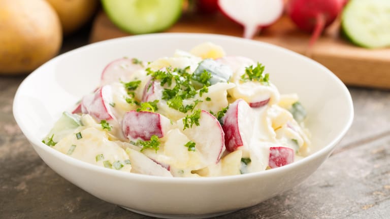 Kartoffelsalat mit Joghurt: Aus Joghurt, Kräutern, Salz, Pfeffer und etwas Olivenöl wird ein leckeres und leichtes Dressing hergestellt.