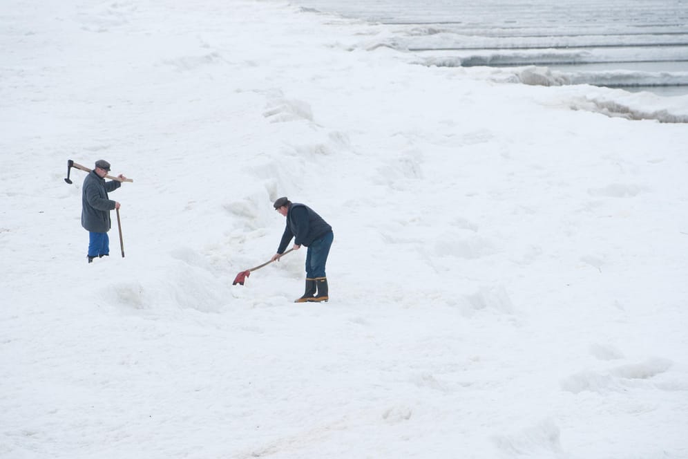 Spürbar Winter: Helfer schlagen auf einem Archivfoto im Ostseebad Koserow Eis. Die besondere Wetterlage könnte zu starken Schneefällen an der Küste führen.