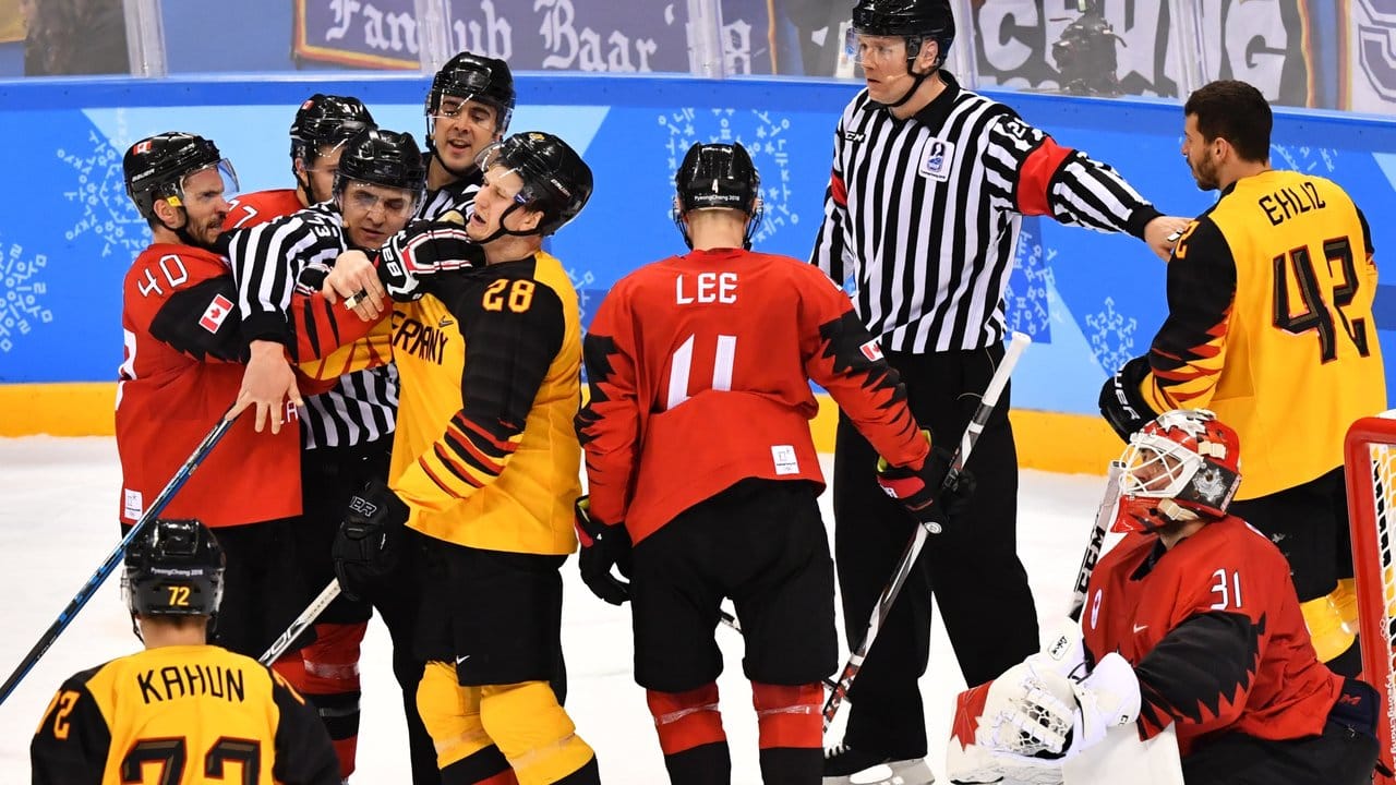 Die Schiedsrichter trennen bei einer Auseinandersetzung die Spieler des kanadischen und deutschen Teams.