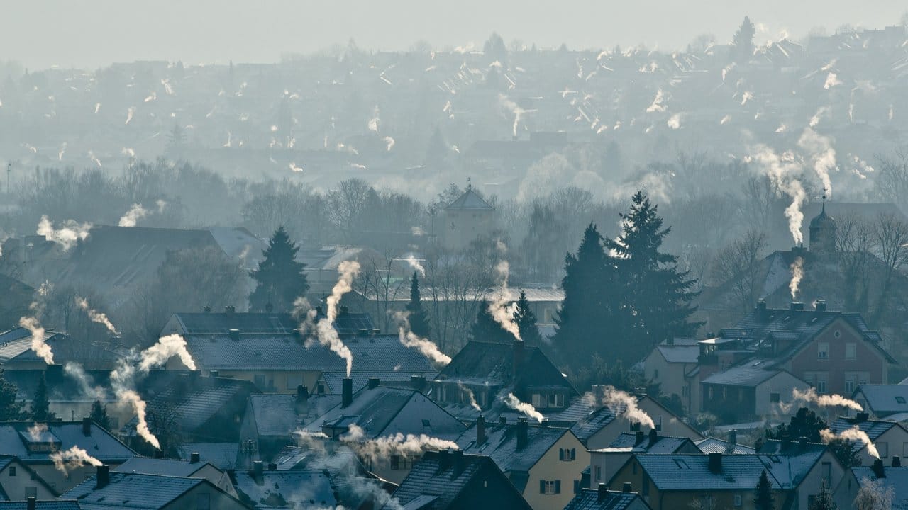 Schornsteine rauchen auf den Dächern der Häuser im bayrischen Kelheim.