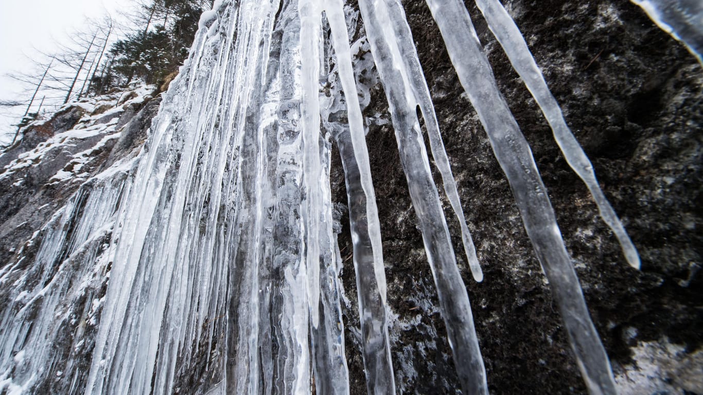 Bayern, Königssee: Lange Eiszapfen hängen an einem gefrorenen Wasserfall herab. Es bleibt bitterkalt in Deutschland.