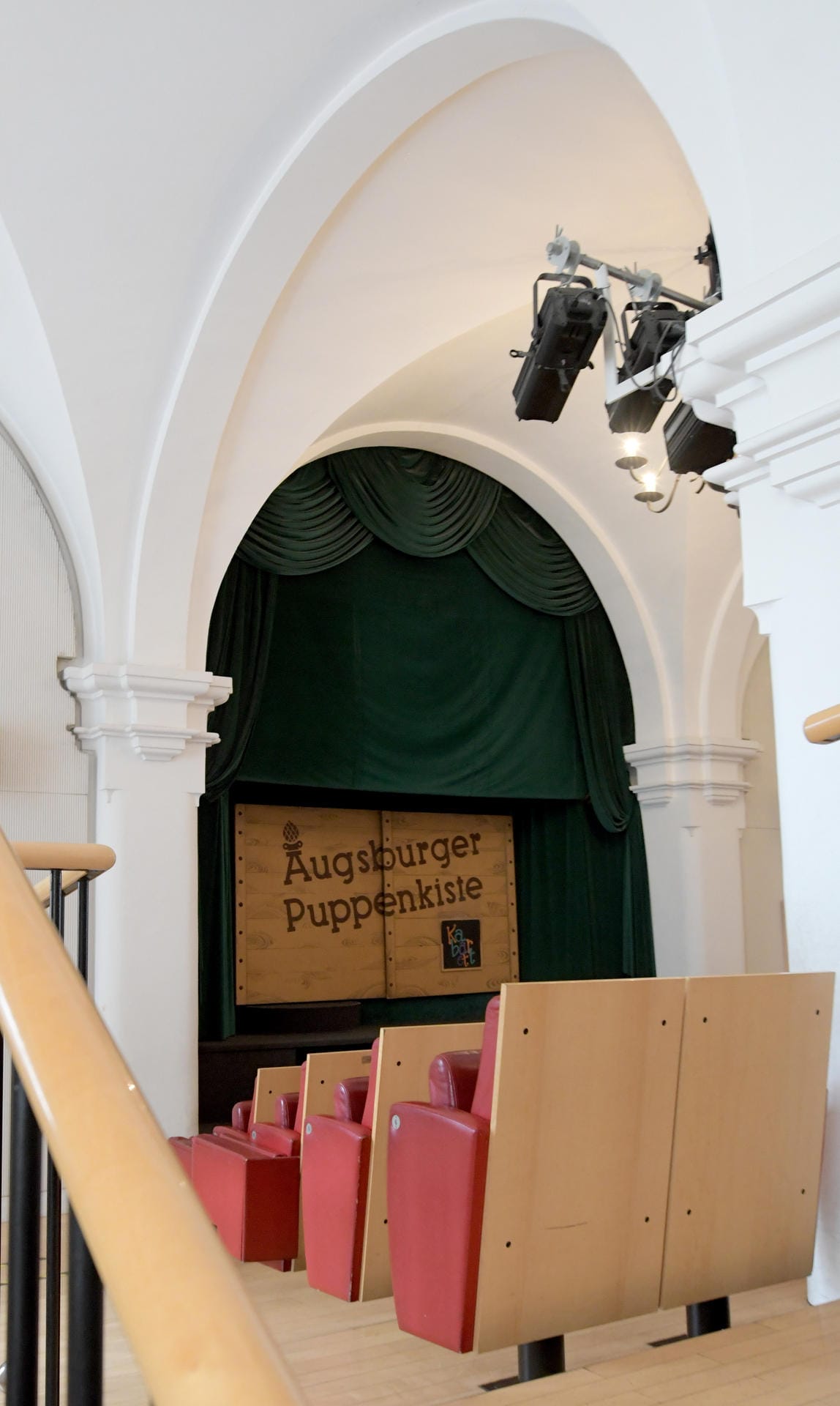 In der Augsburger Puppenkiste ist unter einem grünen Vorhang die Kiste, hinter der sich die Bühne befindet.