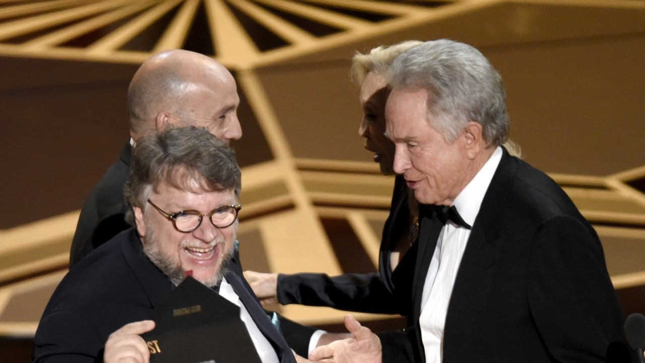 Guillermo del Toro checkt noch einmal den Umschlag, den er von Warren Beatty bekommen hat.