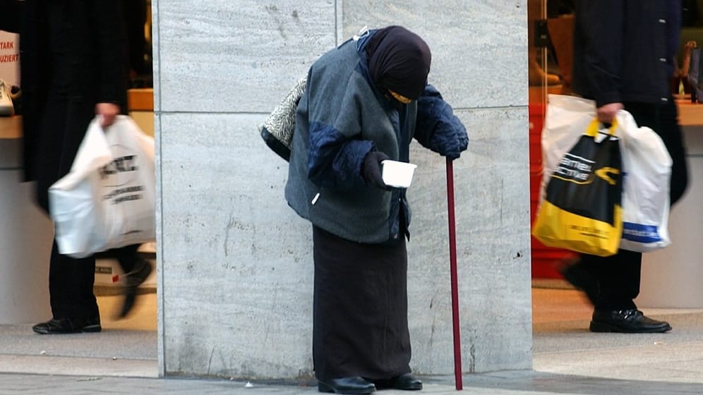 In der Kölner Innenstadt bittet eine alte Frau um Almosen: Über das Ausmaß der Altersarmut wird derzeit gestritten.