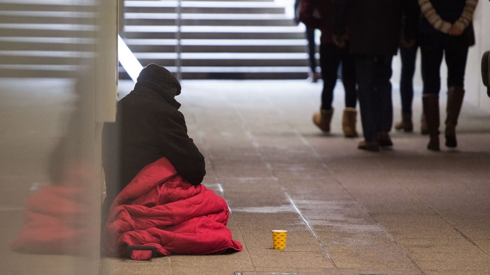 Ein Bettler wartet in einer Unterführung in Stuttgart auf Spenden von Passanten.