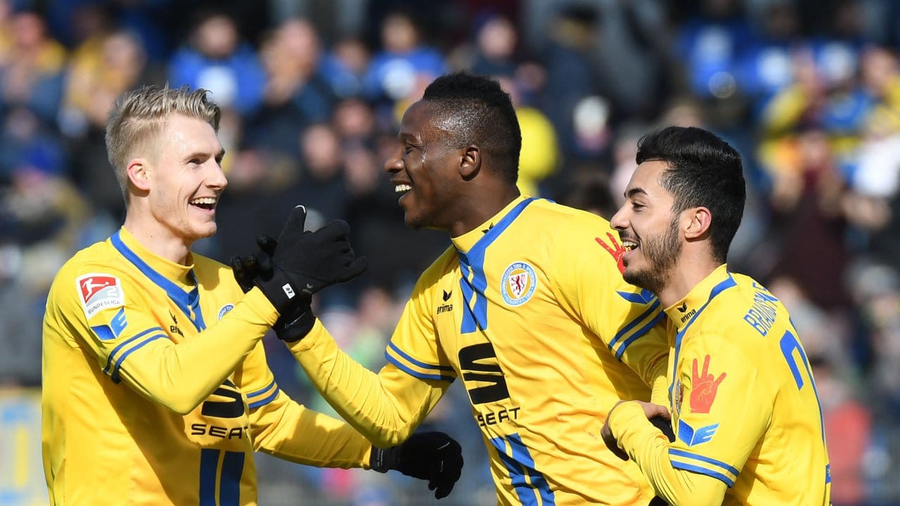 Braunschweigs Suleiman Abdullahi (M) bejubelt seinen Treffer zum 3:0 gegen den MSV Duisburg mit Maximilian Sauer (l) und Salim Khelifi.