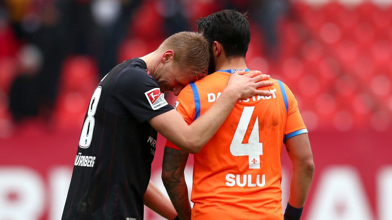Nach dem Remis-Spiel stehen der Nürnberger Hanno Behrens (l) und Darmstadts Aytac Sulu auf dem Spielfeld beisammen.