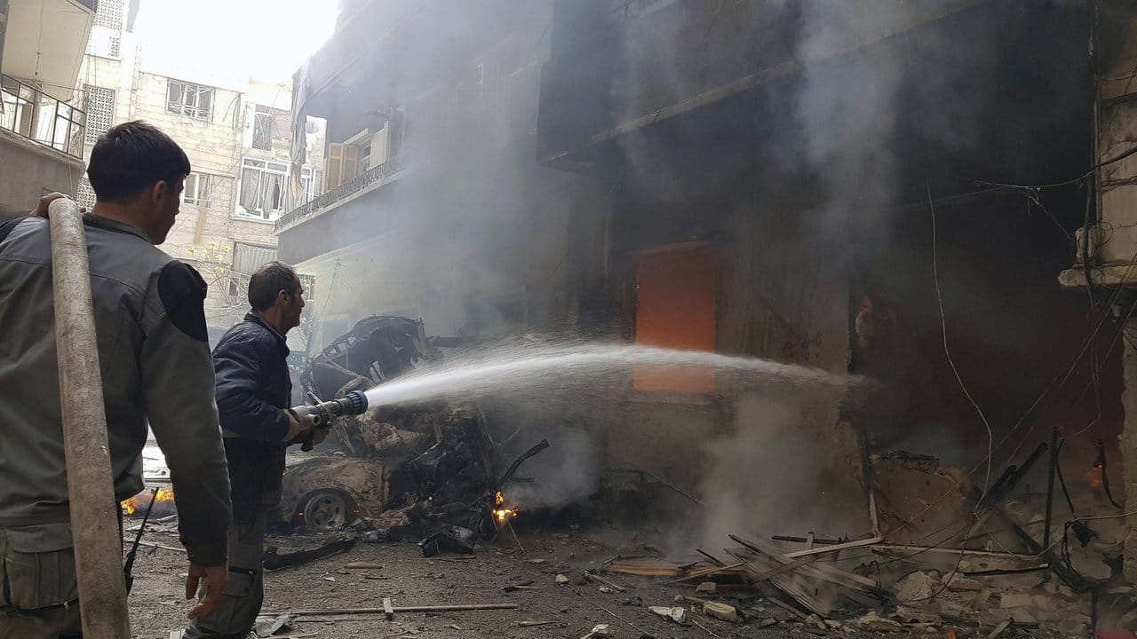 Kein Ende des Kriegs in Syrien: Nach einem Luftangriff versuchen Männer einen Brand zu löschem.