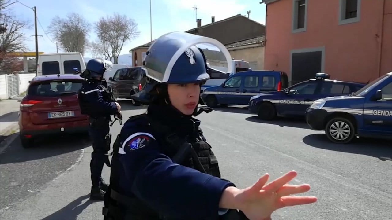 Polizisten sichern während einer Geiselnahme in einem Ort am Rande von Carcassonne eine Straße. Polizisten sichern während einer Geiselnahme in einem Ort am Rande von Carcassonne eine Straße.
