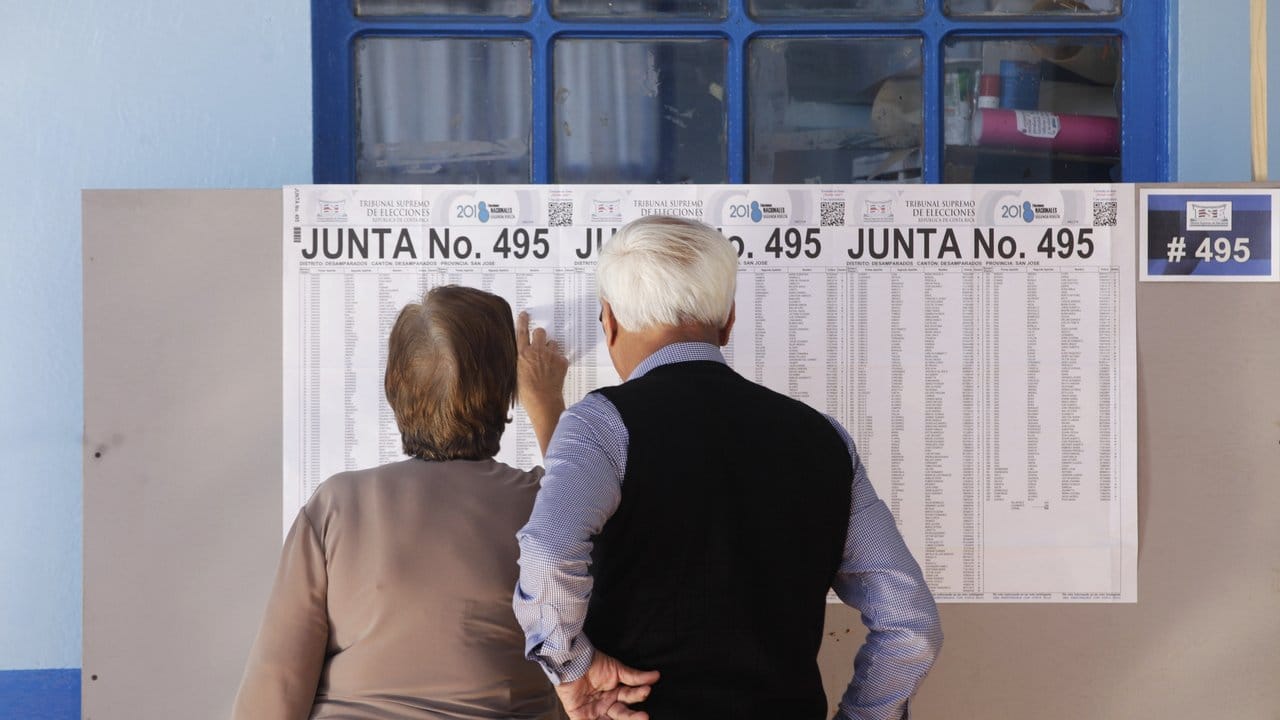 Ein älteres Paar betrachtet in der Hauptstadt San José eine Wahlliste.