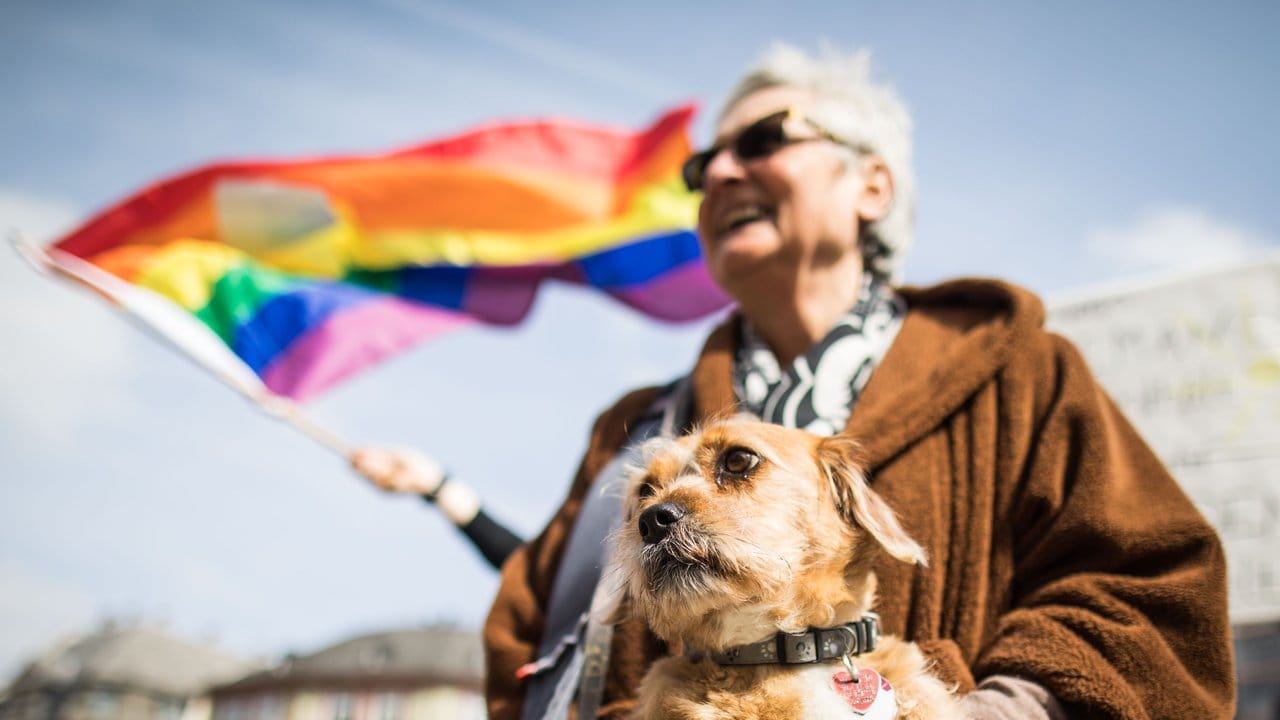 Zusammen mit ihrem Hund nimmt eine Frau an der Abschlusskundgebung auf dem Frankfurter Römerberg teil.