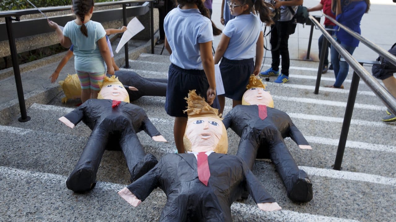 An der riesigen roten Krawatte gut zu erkennen: In den USA geborene Kinder von Migranten protestieren mit Trump-Puppen gegen die Politik des US-Präsidenten.