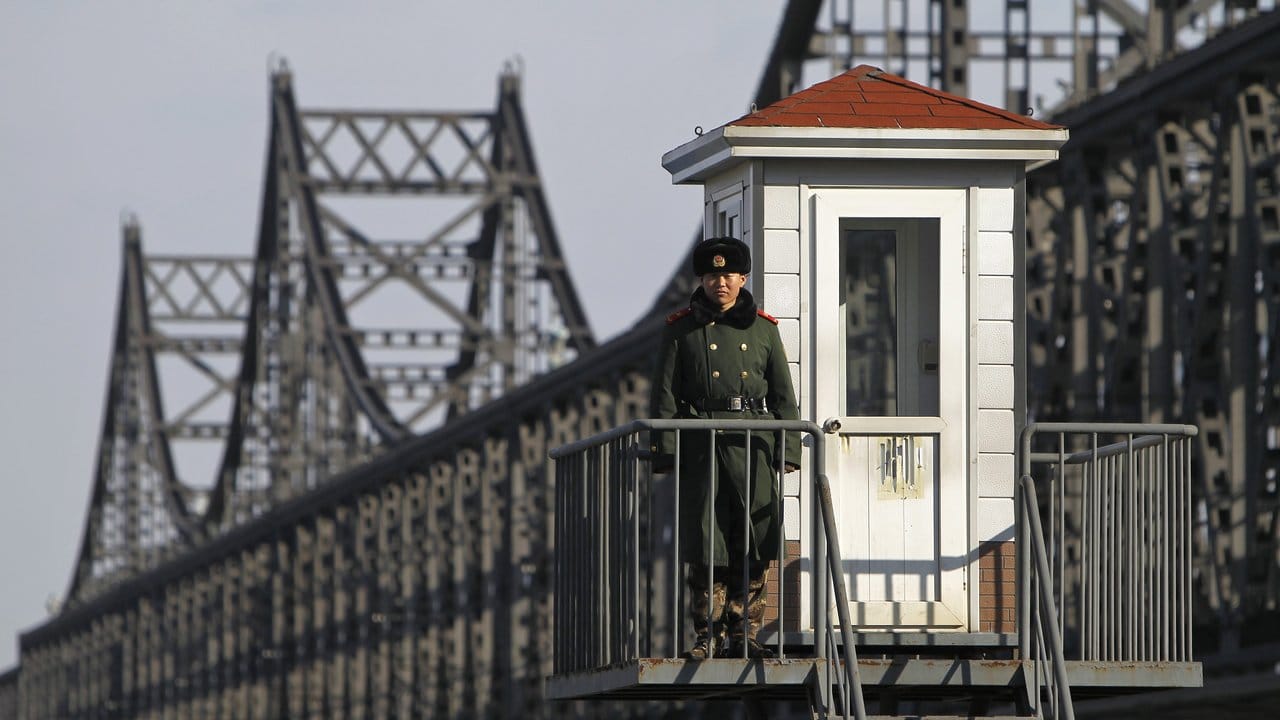 Ein chinesischer Soldat bewacht die Brücke am Grenzfluss zu Nordkorea. Ein chinesischer Soldat bewacht die Brücke am Grenzfluss zu Nordkorea.