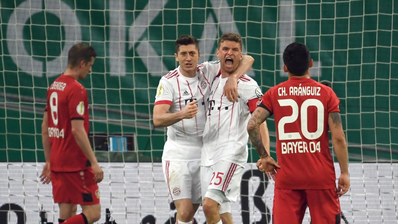 Zweifach-Torschütze Robert Lewandowski gratuliert dem dreimal erfolgreichen Thomas Müller - Leverkusen Spieler resignieren.