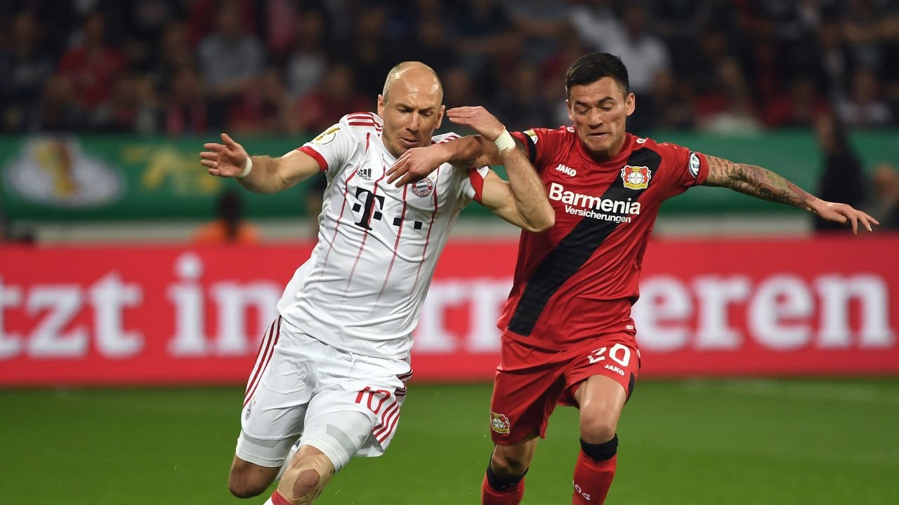 Arm in Arm: Leverkusens Charles Mariano Aranguiz (r) und Bayern-Routinier Arjen Robben beharken sich.