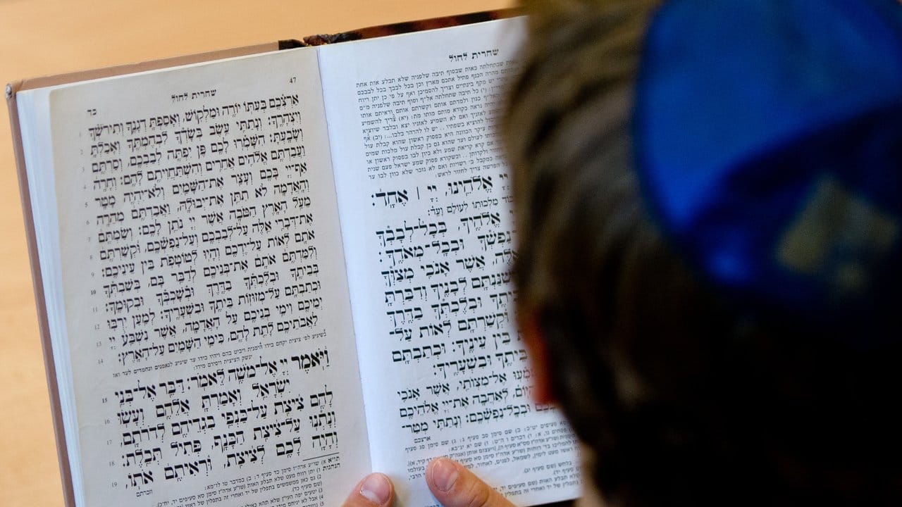 Ein Schüler der Talmud-Tora-Schule in Hamburg mit Kippa liest in einem Gebetsbuch. Ein Schüler der Talmud-Tora-Schule in Hamburg mit Kippa liest in einem Gebetsbuch.