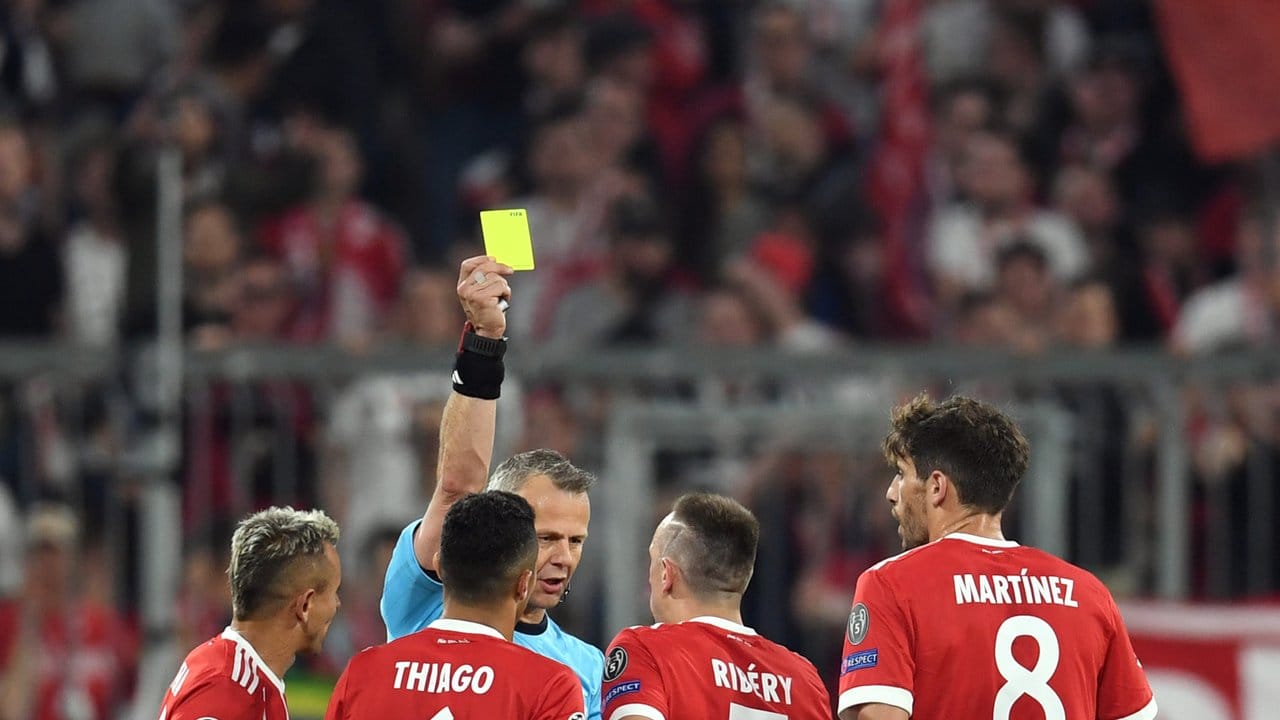 Schiedsrichter Björn Kuipers zeigt Franck Ribery die gelbe Karte.