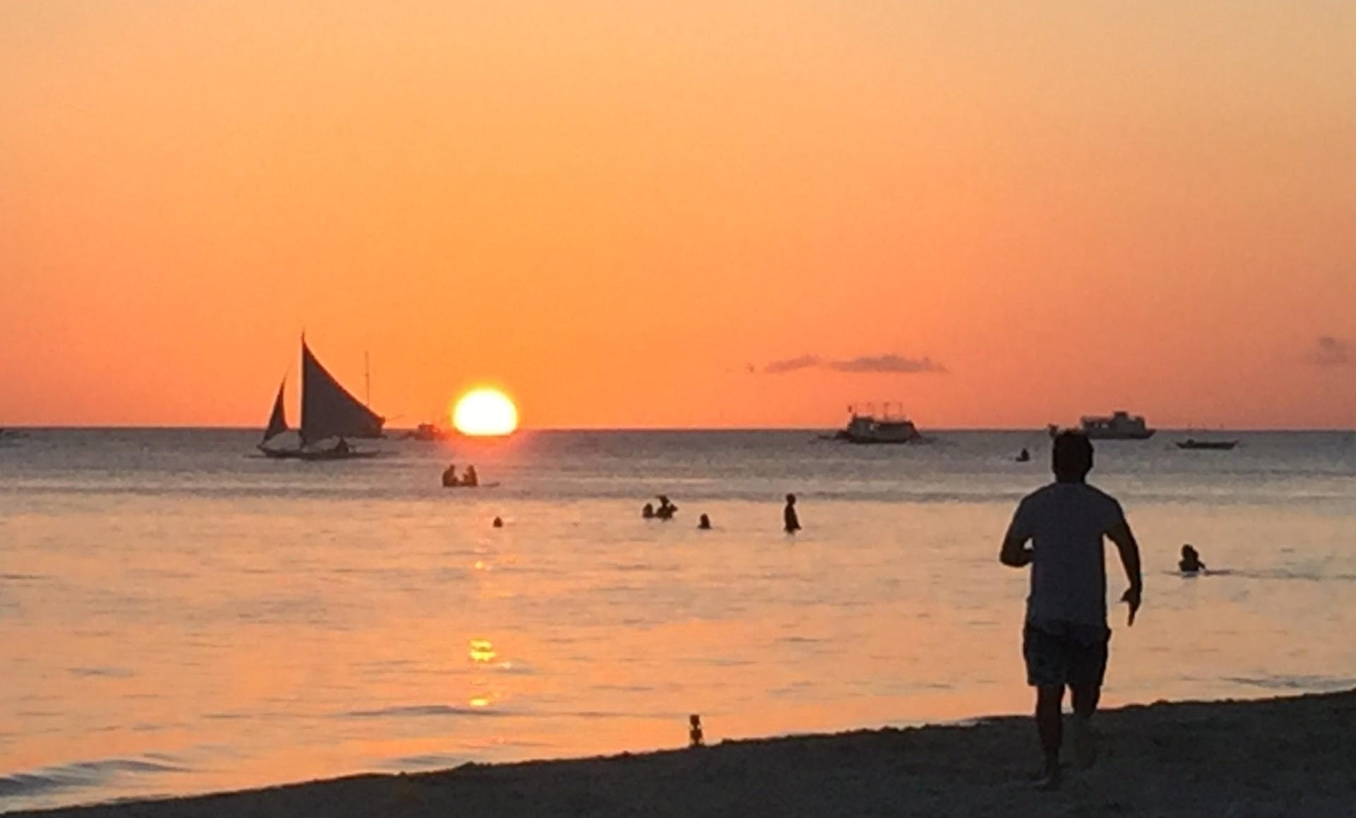 Insel Boracay: Spaziergänger gehen am Strand spazieren und betrachten den Sonnenuntergang.