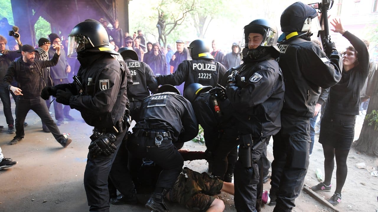 Polizisten setzen einen Teilnehmer der revolutionären 1.