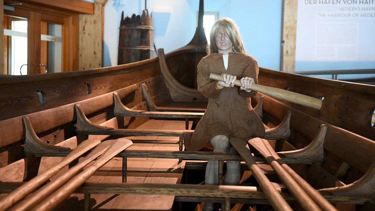 Eine Puppe sitzt im Wikingermuseum Haithabu in einem Boot. Eine Puppe sitzt im Wikingermuseum Haithabu in einem Boot.