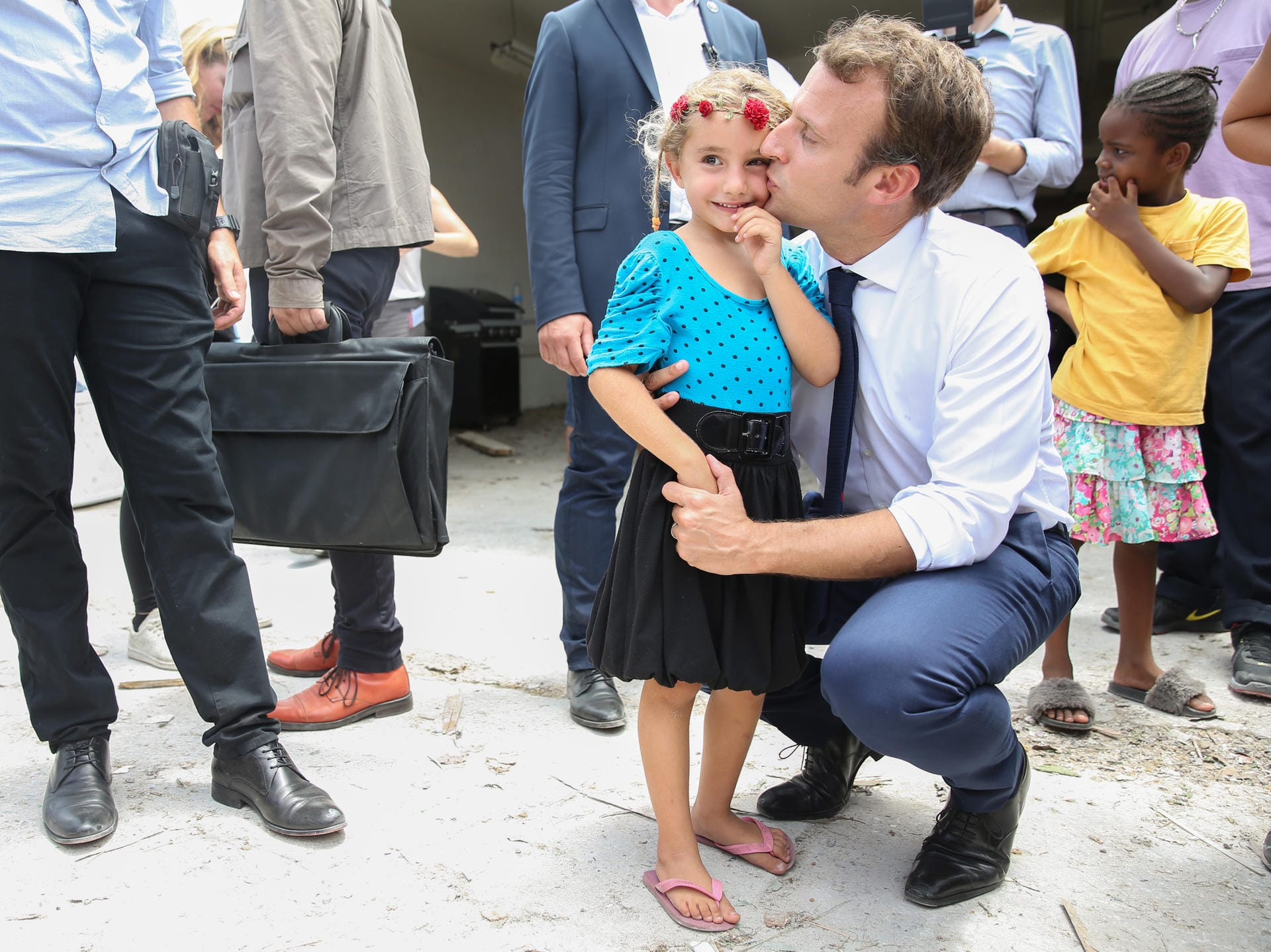 Macron küsst ein kleines Mädchen auf der karibischen Insel Saint Martin nach dem Hurrikan Irma im September 2017: Macron selbst hat keine Kinder, seine Frau brachte 3 Kinder mit in die Ehe. Eine ihrer Töchter ging mit Macron zur Schule.